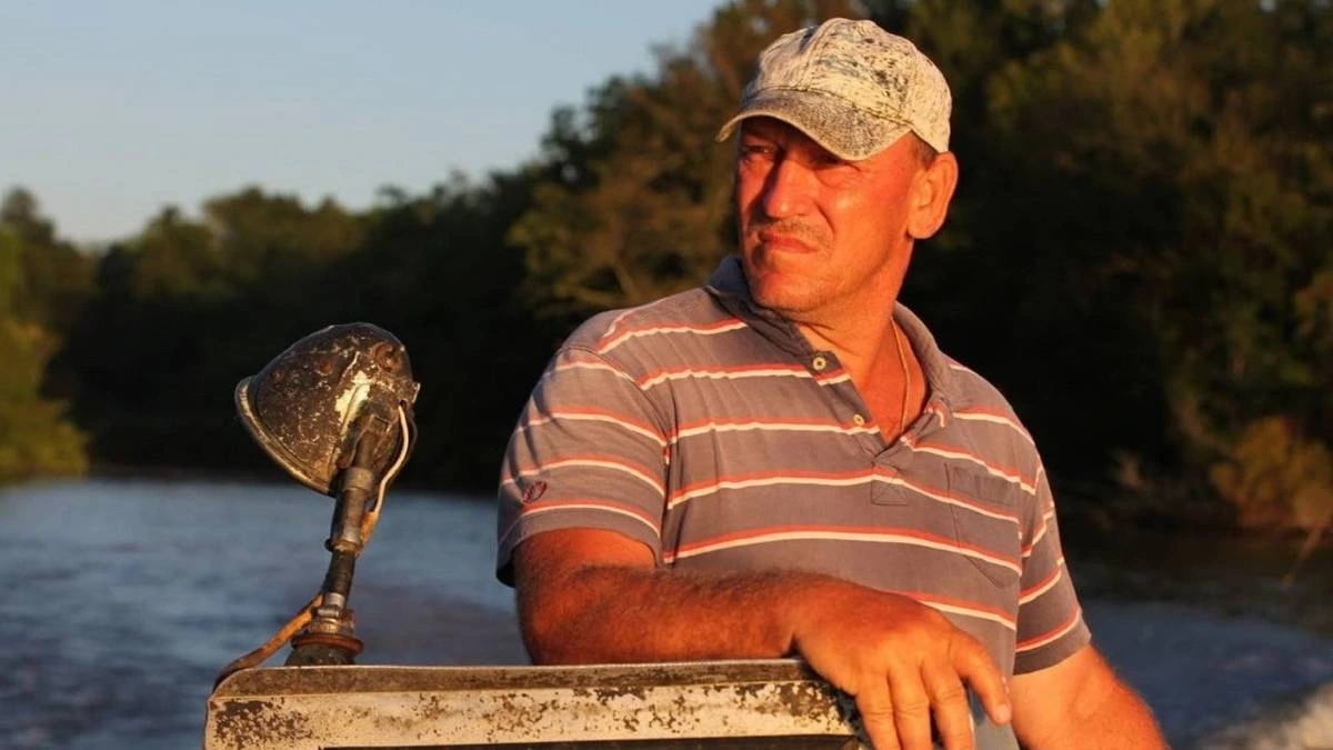 Troy Landry on a boat in the swamp at sunset